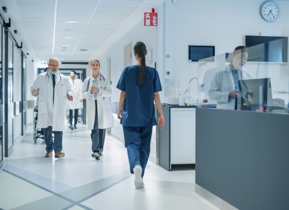 Diverse,Male,And,Female,Medical,Professionals,Walk,In,A,Busy