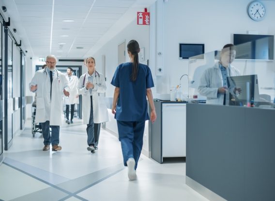 Diverse,Male,And,Female,Medical,Professionals,Walk,In,A,Busy